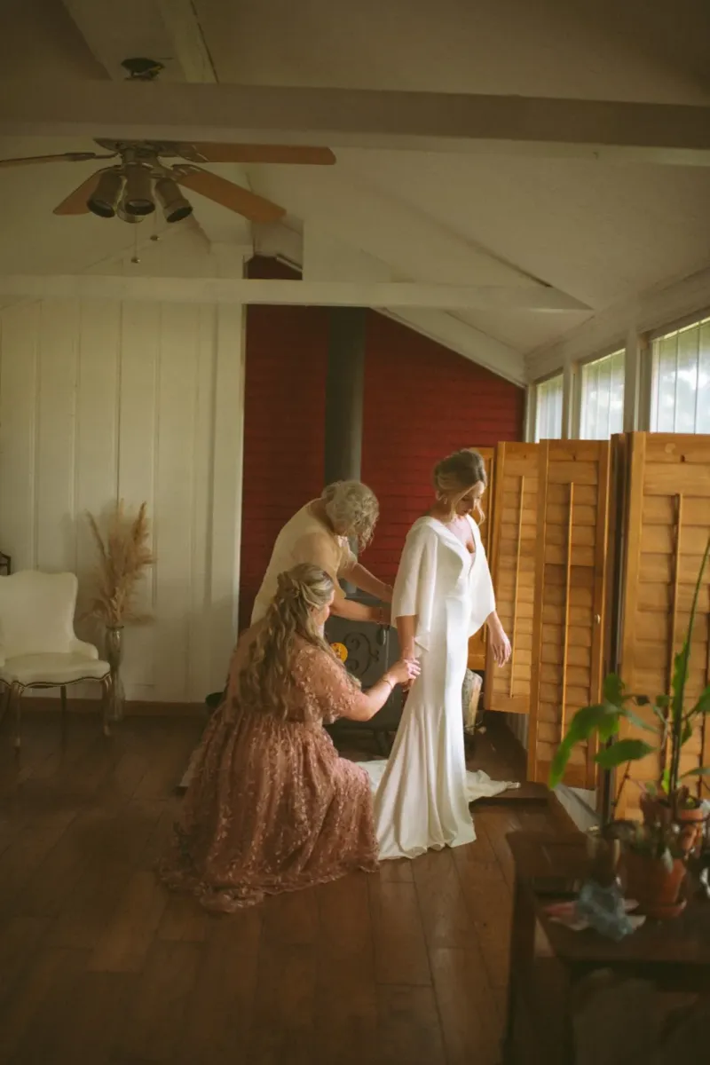 Bride getting ready with bridesmaids in elegant white wedding gown