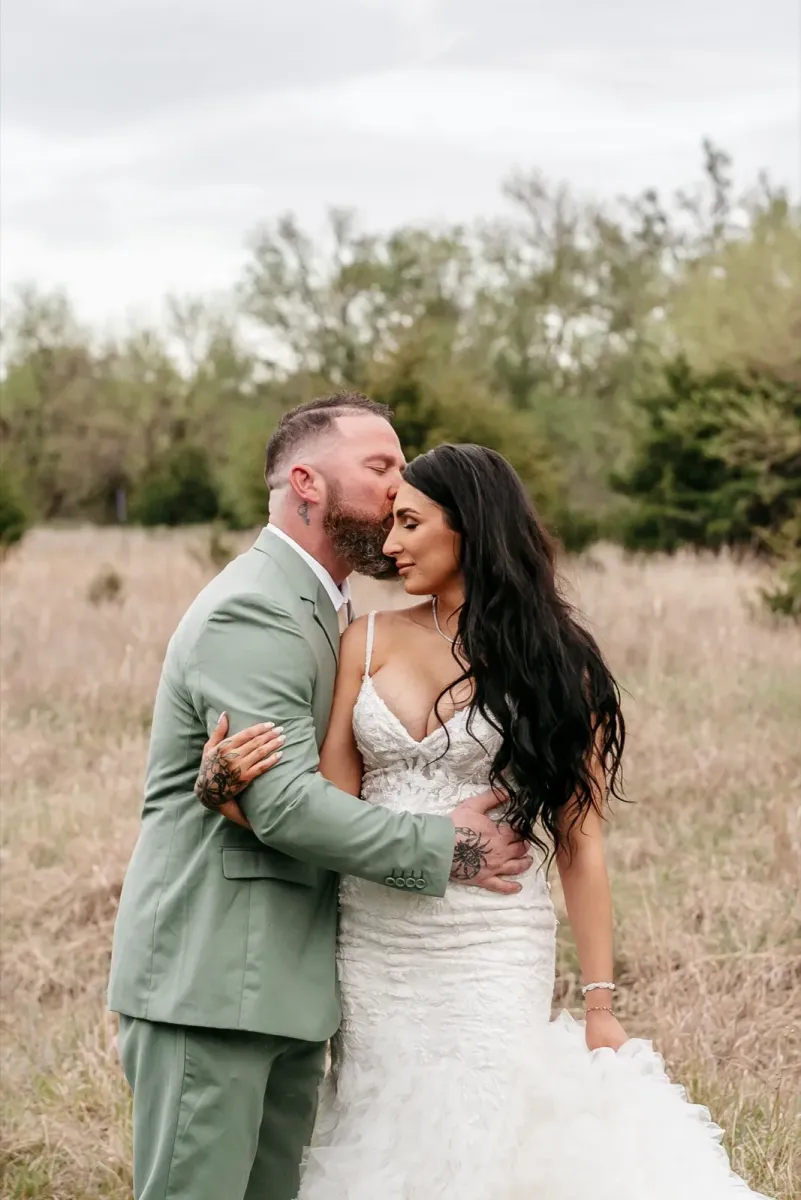 Romantic outdoor wedding couple portrait in field at sunset