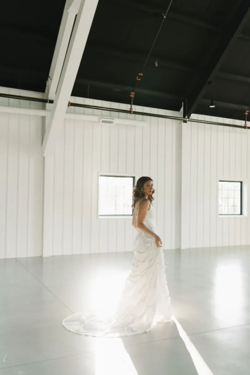 Elegant bride in minimalist white gown in modern industrial space