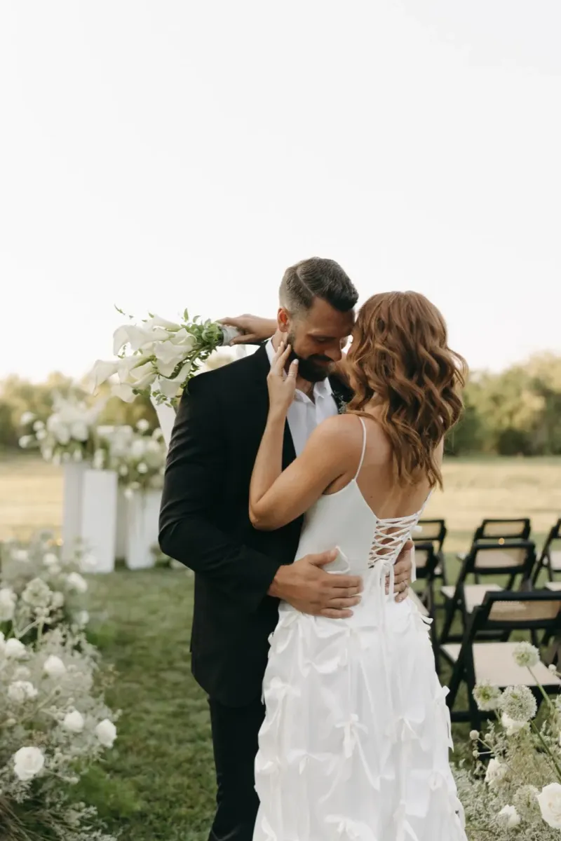 Emotional wedding ceremony moment with white lily bouquet