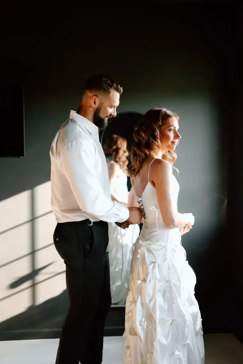 Intimate wedding couple moment with dramatic natural window lighting