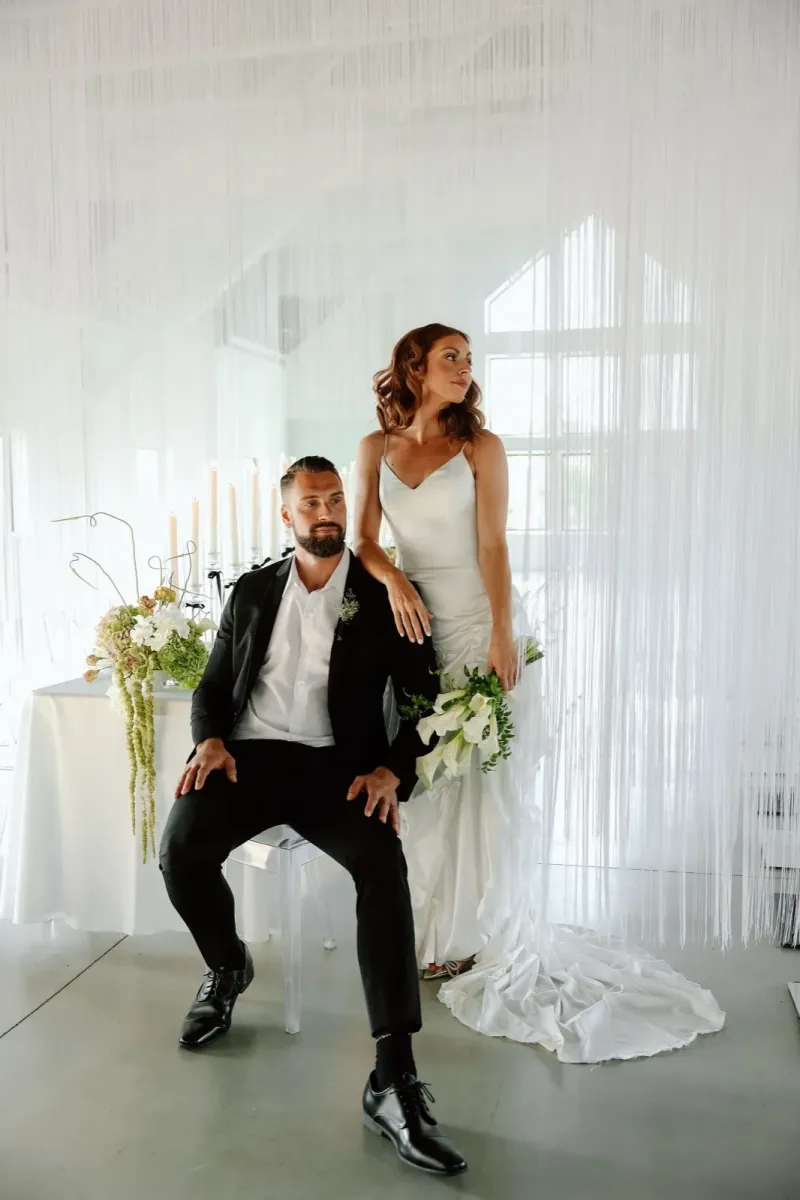 Modern editorial wedding portrait with dramatic white installation backdrop