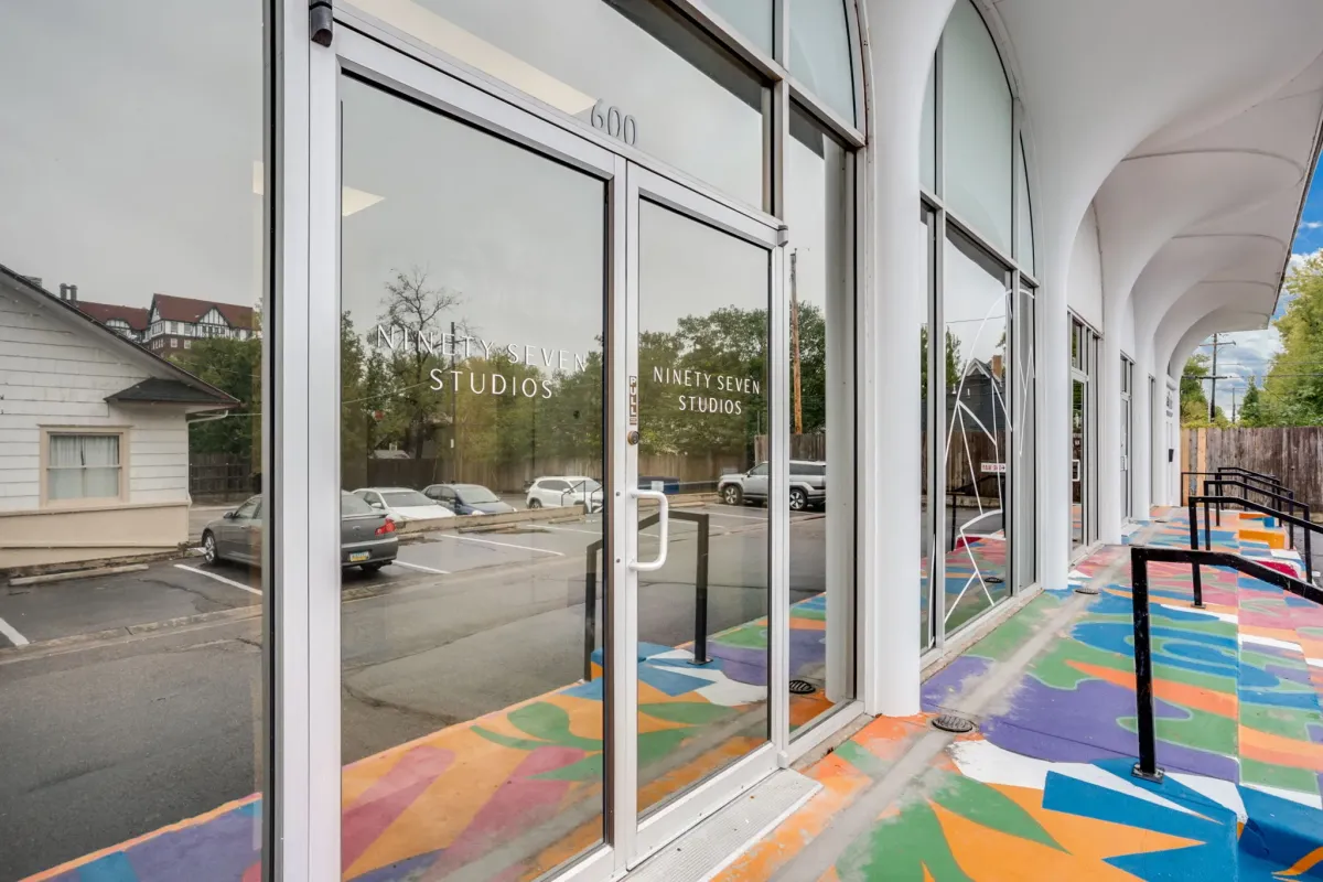 Salon entrance with glass doors and colorful painted concrete entryway
