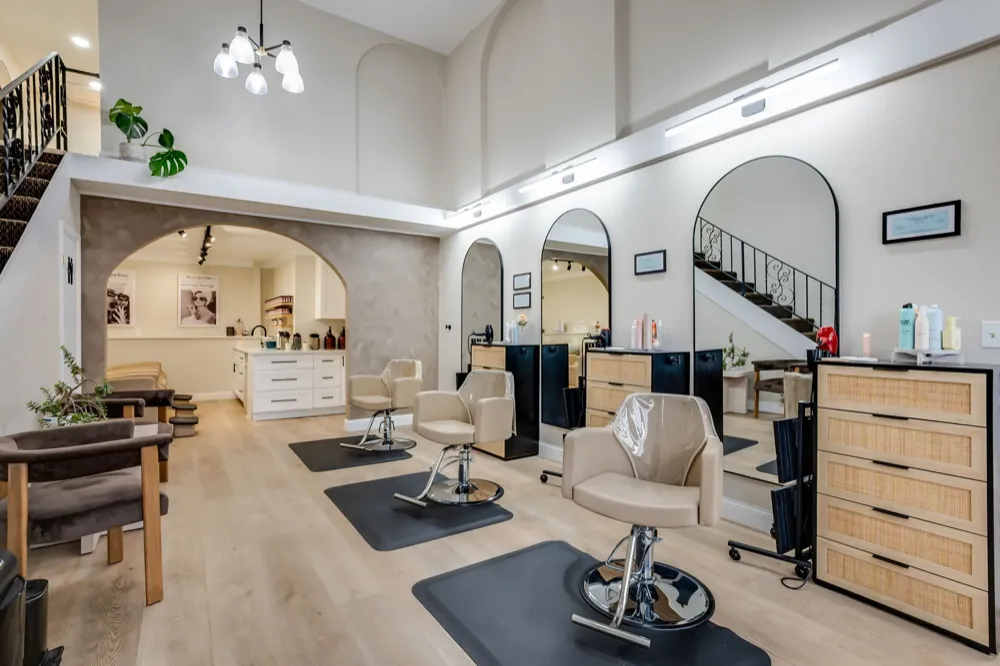 Spacious modern salon interior with styling stations and natural lighting