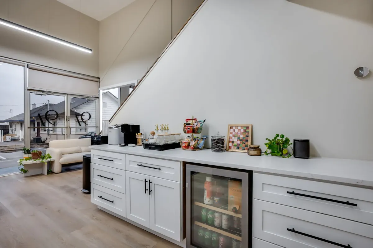 Salon beverage bar with white cabinetry and modern amenities