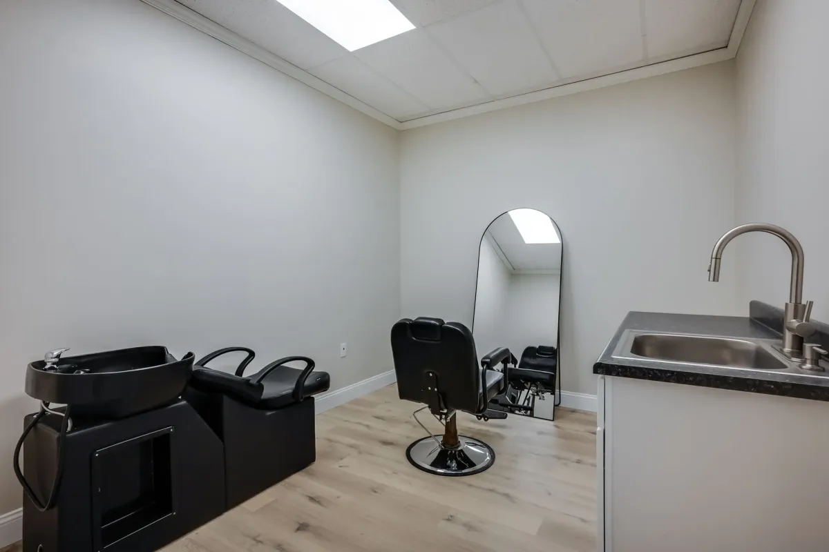 Private salon studio with black styling chair and skylight
