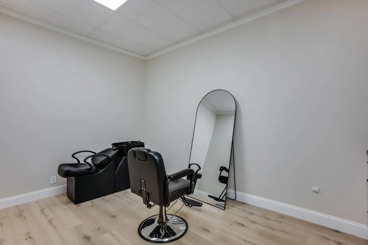 Minimalist salon suite with black equipment and full-length mirror